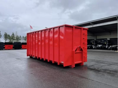 Röd allround container framför carport.