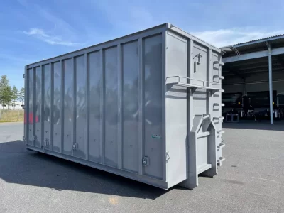 Grå container framför carport.