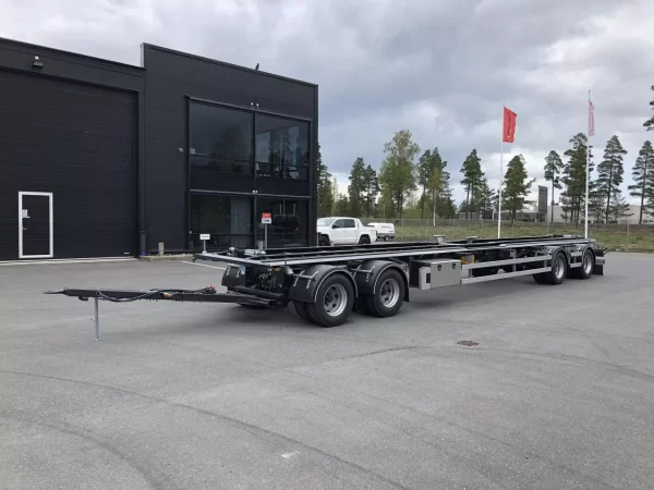 Lastväxlarvagn med rullbanor med kontorslokal och träd i bakgrunden.