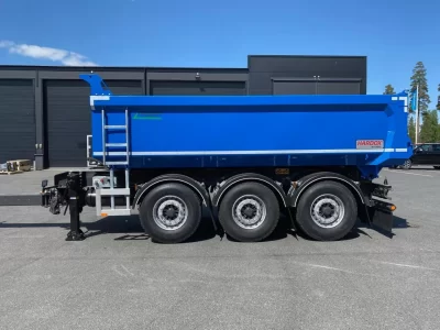 En blå dumperkärra på gårdsplan.