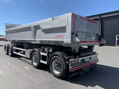 En tipper framför ett garage.