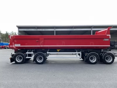 En röd dumper framför uppställningsplats.