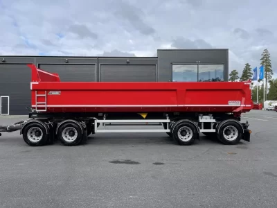 En röd dumper framför kontor.