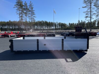 Lastväxlarflak med aluminiumlämmar grusförstärkt från sidan med träd i bakgrunden.
