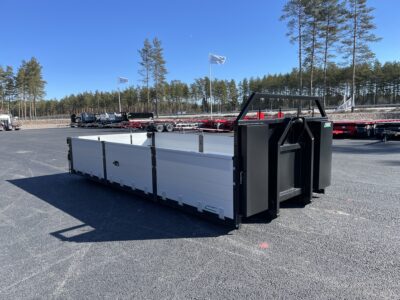 Lastväxlarflak med aluminiumlämmar grusförstärkt, snett framifrån med flaggor bakom.