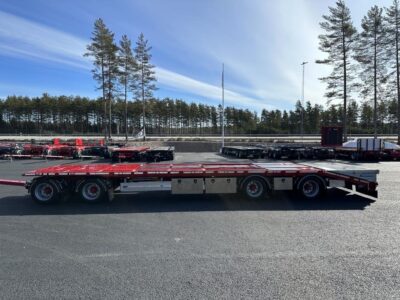 Röd bodvagn med stor flakyta från sidan framför E4:an.