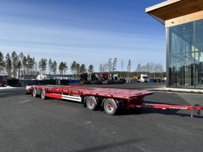 Kombivagn med fordon och byggnad bakom.