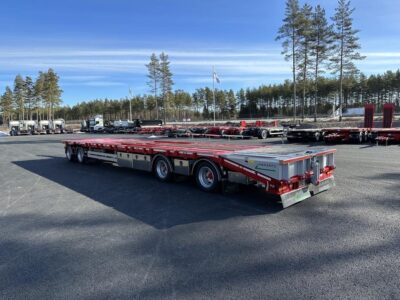 Kombivagn med träd och flaggor i bakgrunden.