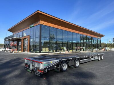 Kombivagn ståendes framför större byggnad.