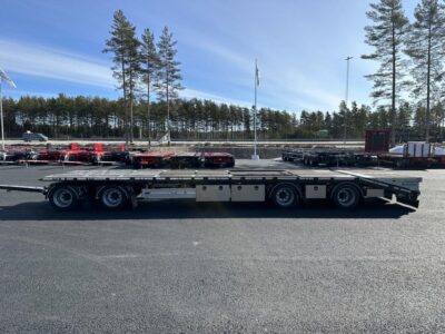 En kombivagn uppställd framför trädlinje.