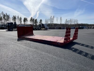 Röd maskinflak med blå himmel bakom.