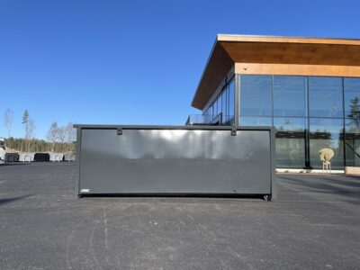 Svart container framför kontorsbyggnad.