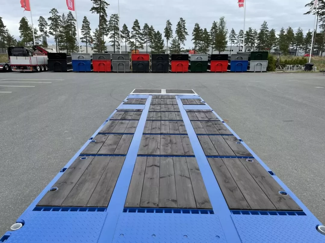 Framför lastväxlarflak står en blå maskinvagn.