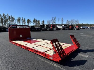 Maskinflak med stegar i flaket framför flera andra fordon.