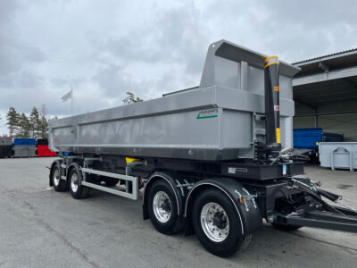 Grå större dumpervagn med stort öppet garage bakom.