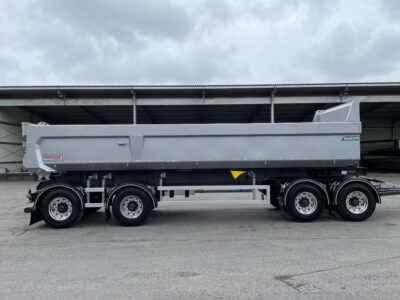 Större grå dumpervagn med öppet garage bakom.