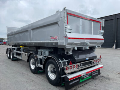 Grå dumpervagn med större svart garage bakom.