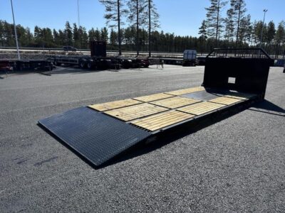 Maskinflak med fast ramp framför större väg.