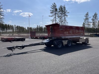 röd 30 ton dumperkärra med flera tallar och flaggor i bakgrunden.