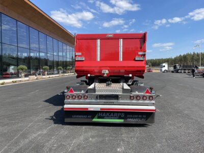 Röd 30 ton dumperkärra med fordon i bakgrunden.