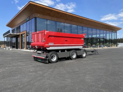 Röd 30 ton dumperkärra framför kontor och garage