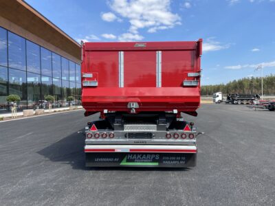 röd 30 ton dumperkärra, sedd bakifrån, på gårdsplan