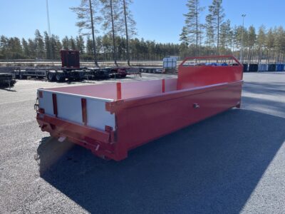 Ett schaktflak i färgen röd ståendes utomhus, sett snett från sidan.